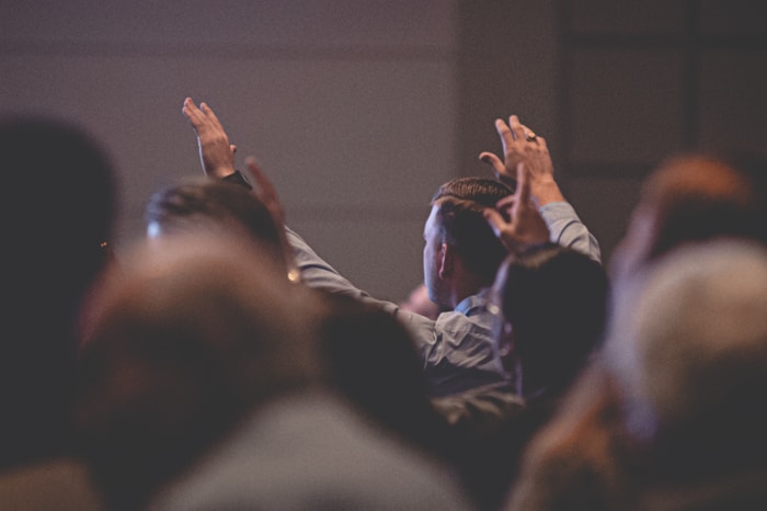 Congregation raising hands in worship at Glory Ministries